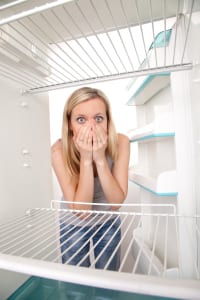 Women opening the fridge looking shocked