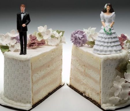 Wedding cake split in half with bride on one half and groom on other half.