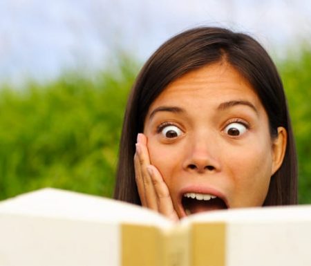 Lady reading a book looking surprised