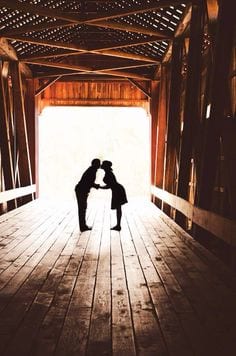 Couple kissing in an old covered bridge