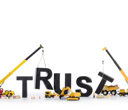 Construction vehicles putting the word "TRUST" together.