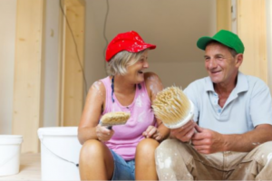 couple sitting on step with paint brushes