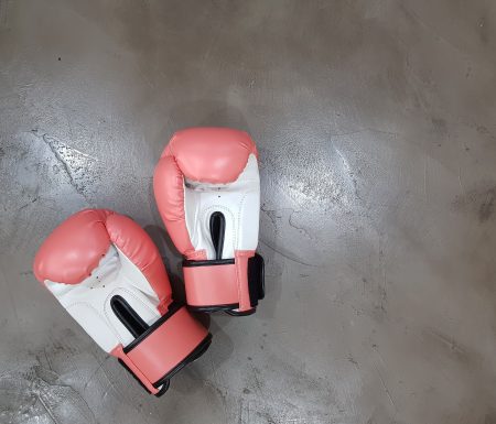 Pink boxing gloves laying on floor