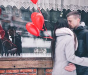 Couple kissing and holding heart balloons