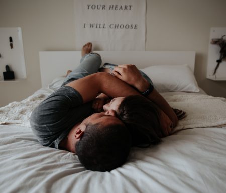 Couple in bed holding each other