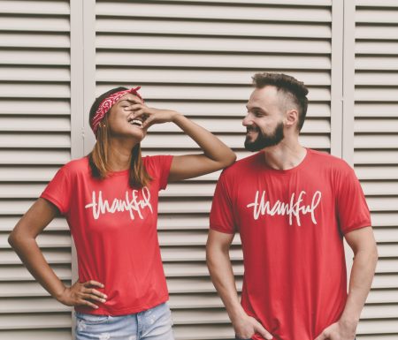 Couple laughing together wearing matching thankful shirts