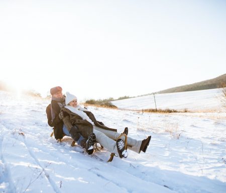 Couple sledding in snow