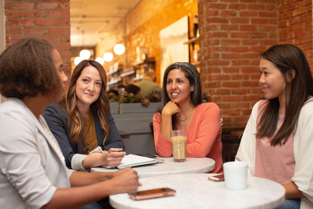4 females sitting at coffee spot talking